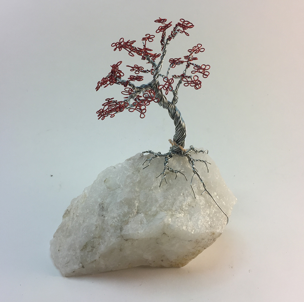 silver tree with red foliage on white quartz